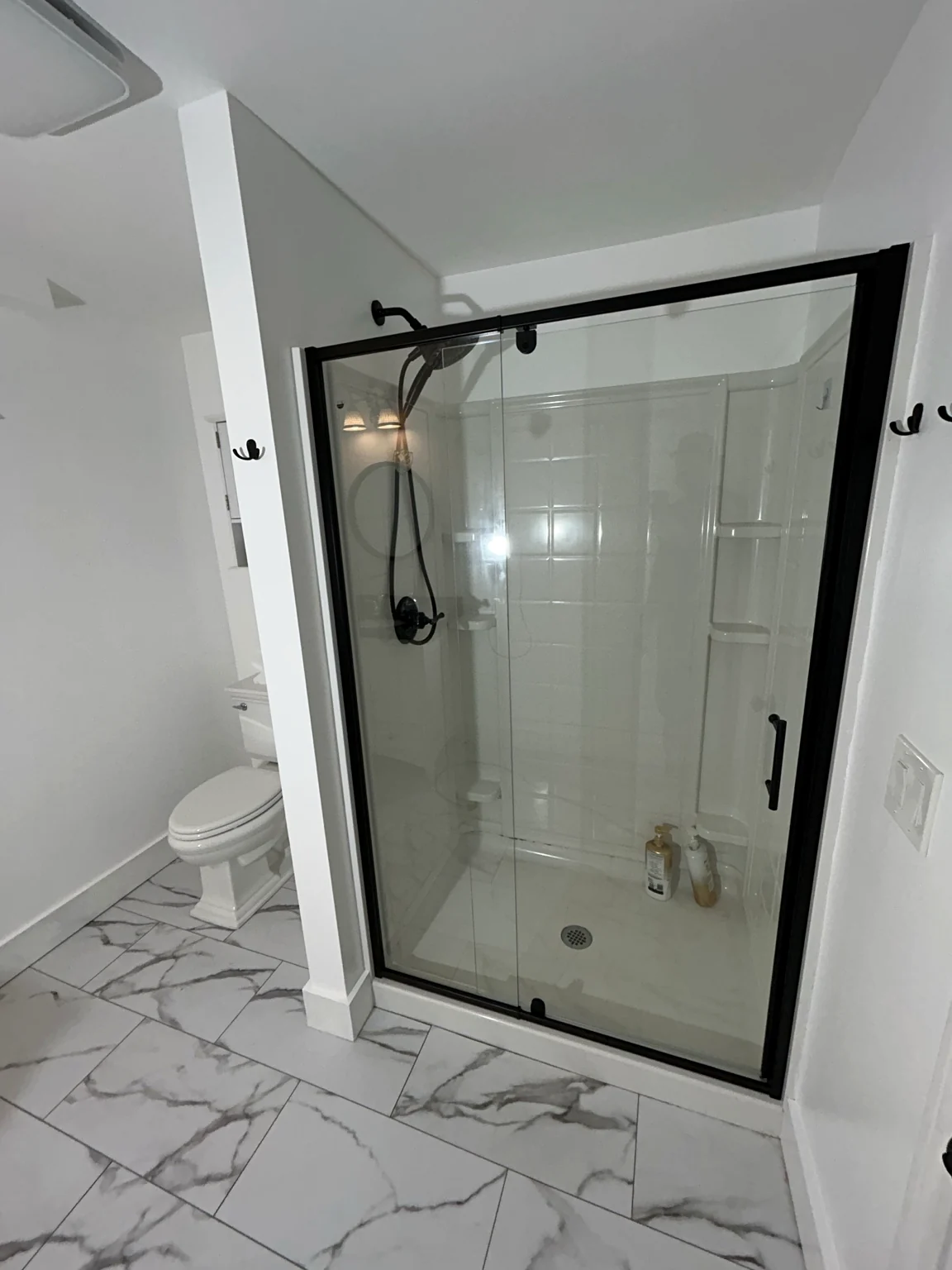 Bathroom renovation with black framed glass shower