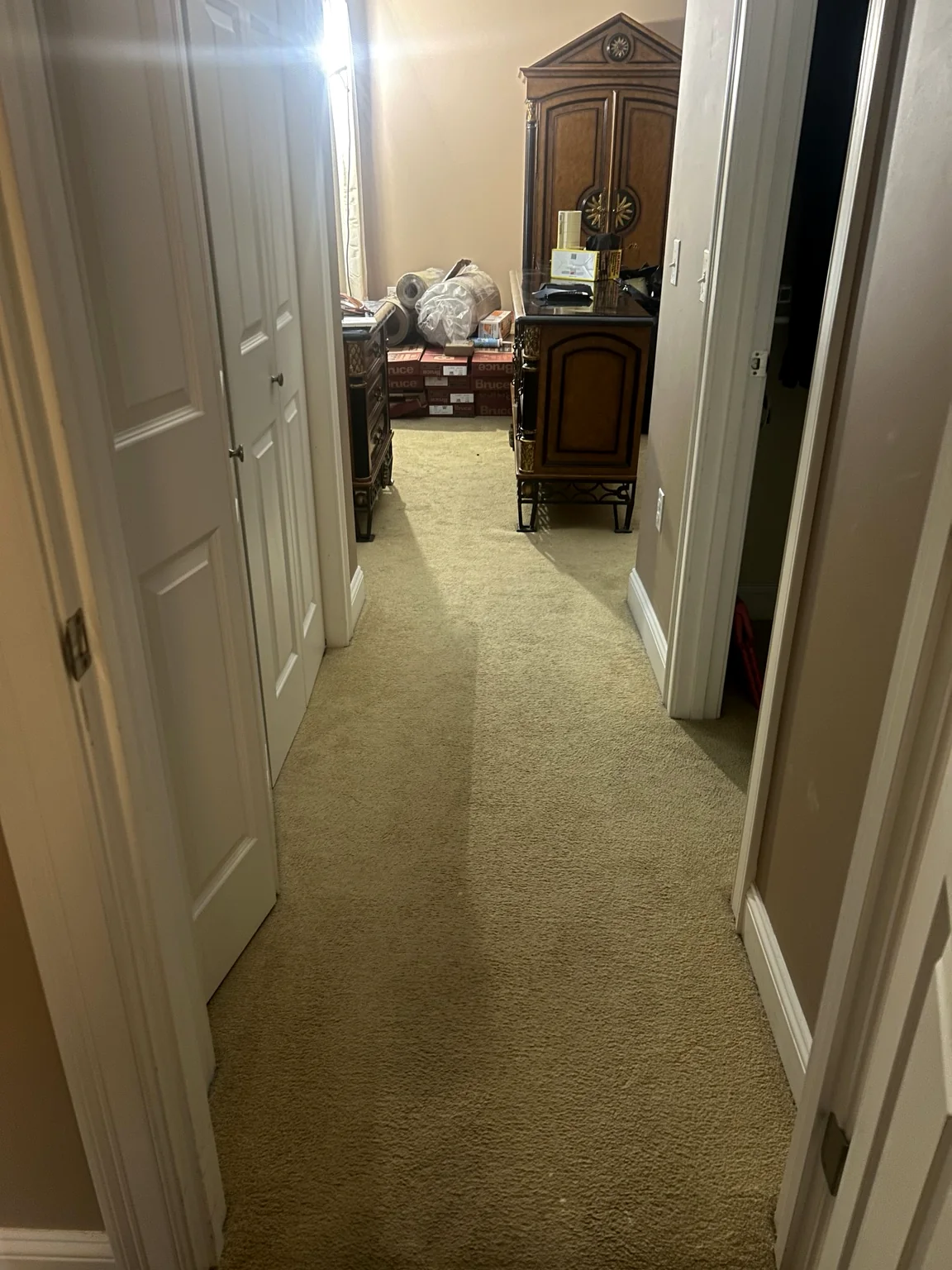 Carpeted hallway before hardwood installation
