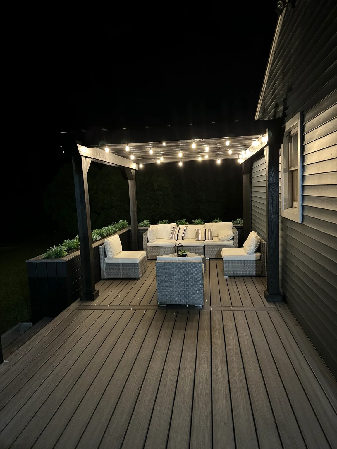 Finished composite deck and pergola illuminated at night