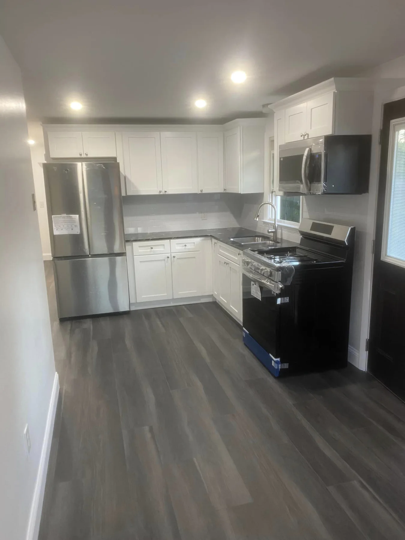 Modern renovated kitchen with new flooring and appliances